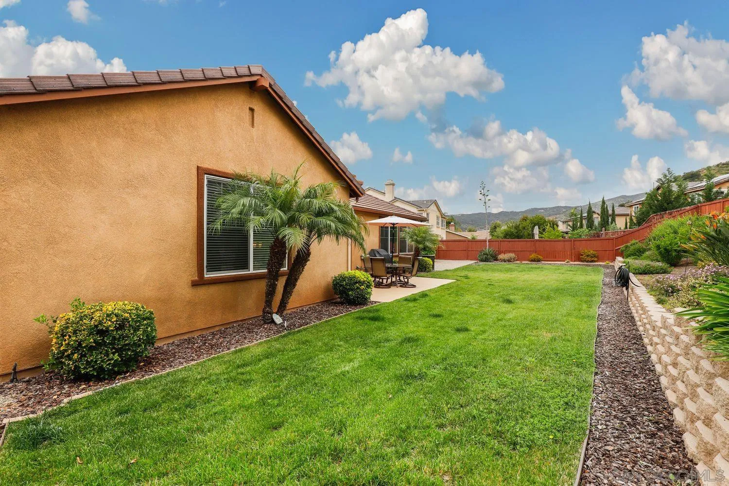 3250 Beven Drive Escondido, CA 92027 - Photo 29 of 34 a view of a backyard with couches under an umbrella