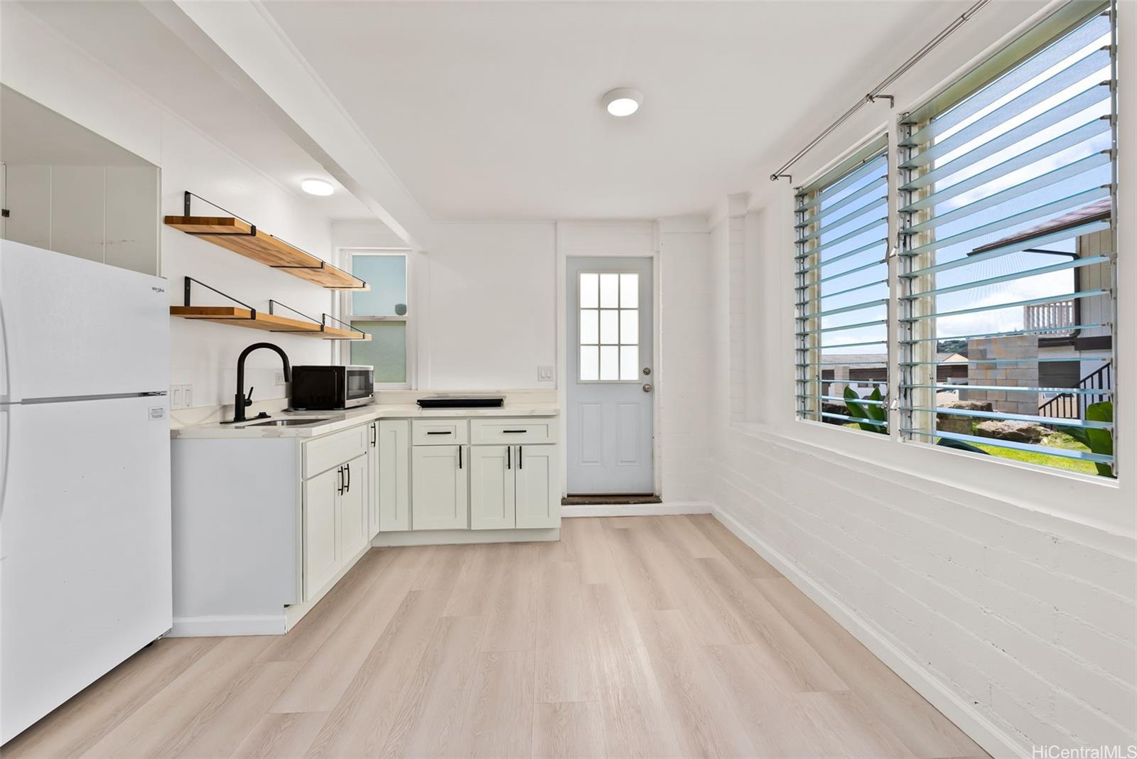 2811 Henry Street Honolulu, HI 96817 - Photo 17 of 25 Flooded with natural light through classic jalousie windows, this flexible lower space feels incredibly warm and inviting.