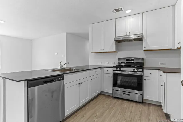 a kitchen with granite countertop a sink and cabinets