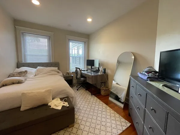 a bedroom with a bed and wooden floor