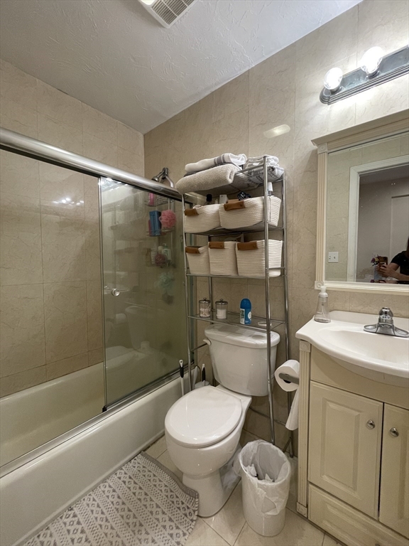 191 Winthrop Road, Unit 2 Brookline, MA 02445 - Photo 11 of 15 a bathroom with a granite countertop toilet a sink a mirror and shower