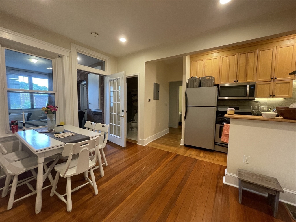 191 Winthrop Road, Unit 2 Brookline, MA 02445 - Photo 4 of 15 a view of a dining room with furniture a kitchen and chandelier