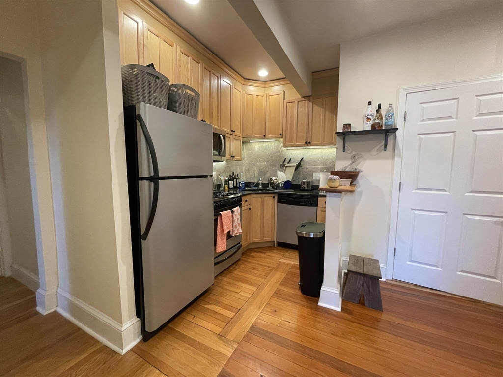 191 Winthrop Road, Unit 2 Brookline, MA 02445 - Photo 5 of 15 a kitchen with stainless steel appliances granite countertop a refrigerator a stove and a wooden floor