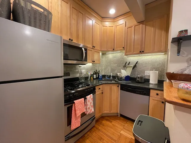 a kitchen with stainless steel appliances a refrigerator stove top oven and sink