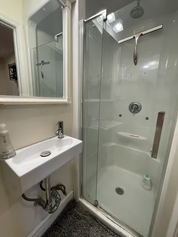 a bathroom with a shower sink and mirror