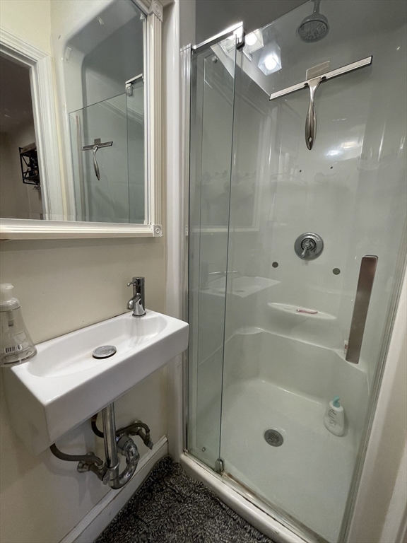 191 Winthrop Road, Unit 2 Brookline, MA 02445 - Photo 8 of 15 a bathroom with a shower sink and mirror