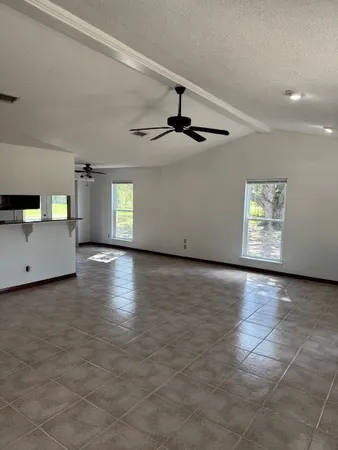 a view of a livingroom with wooden floor and a kitchen space