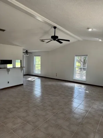 a view of a livingroom with wooden floor and a kitchen space