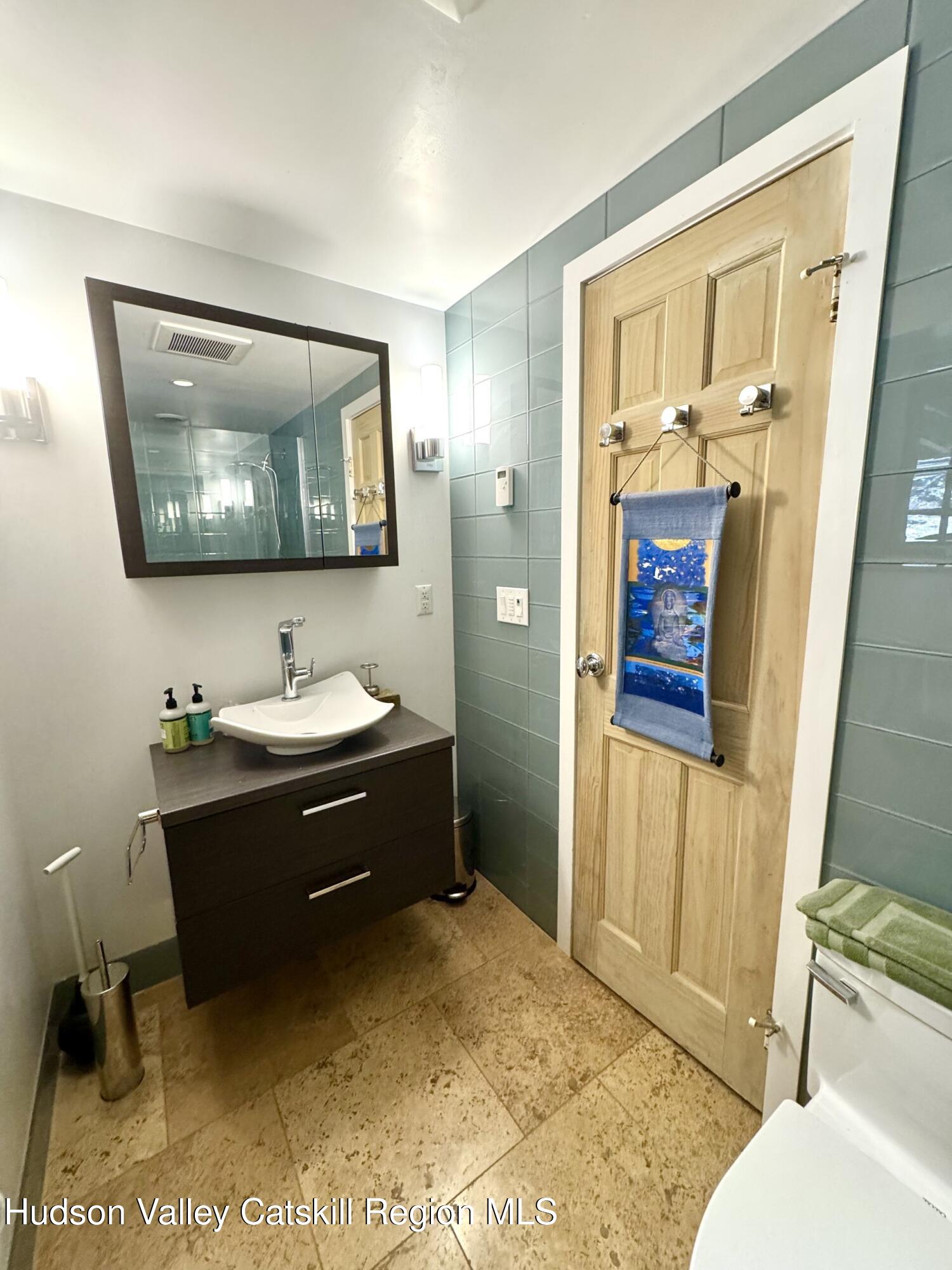 115 Jones Quarry Road Woodstock, NY 12498 - Photo 29 of 38 a bathroom with a sink a mirror and a toilet