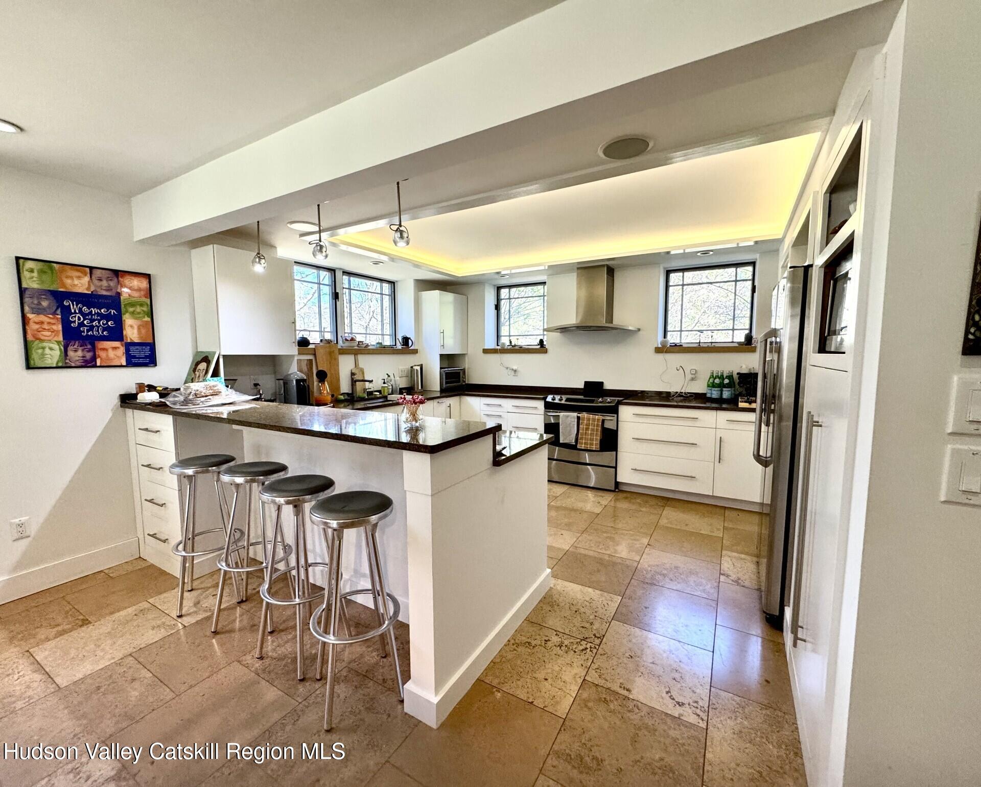 115 Jones Quarry Road Woodstock, NY 12498 - Photo 6 of 38 a kitchen with stainless steel appliances granite countertop a stove top oven a sink a dining table and chairs