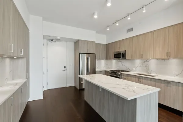 a kitchen with stainless steel appliances a sink stove and refrigerator