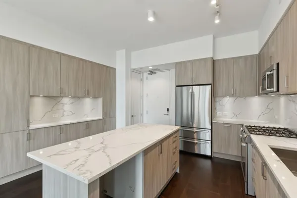 a kitchen with a refrigerator a sink and a stove top oven