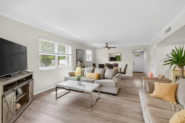a living room with furniture a flat screen tv and a window