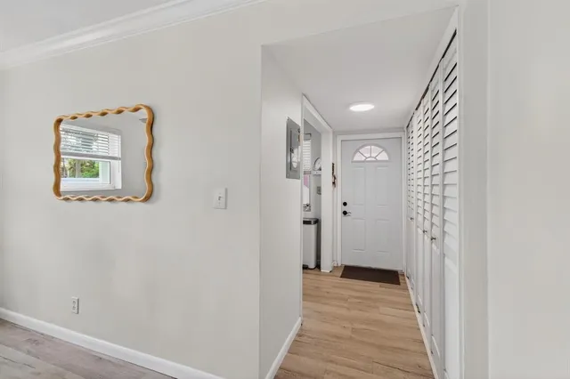 a view of a hallway with wooden floor and a bathroom