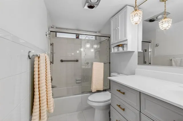 a bathroom with a sink a toilet a mirror and shower