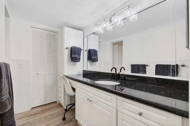 a granite bathroom with double vanity and a mirror