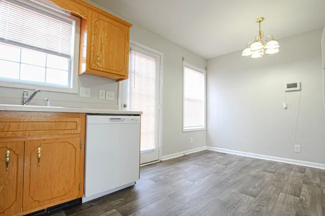 a view of a kitchen with a sink dishwasher and wooden cabinets