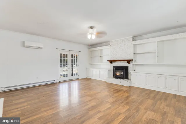 a view of an empty room with a fireplace and a window