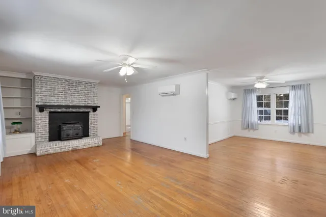 an empty room with windows and a fireplace