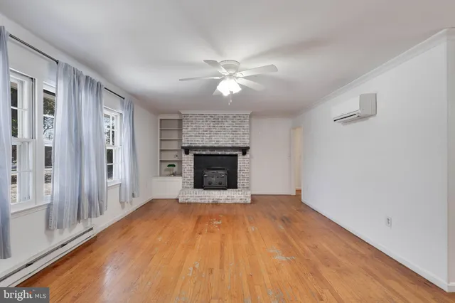 an empty room with windows and a fireplace
