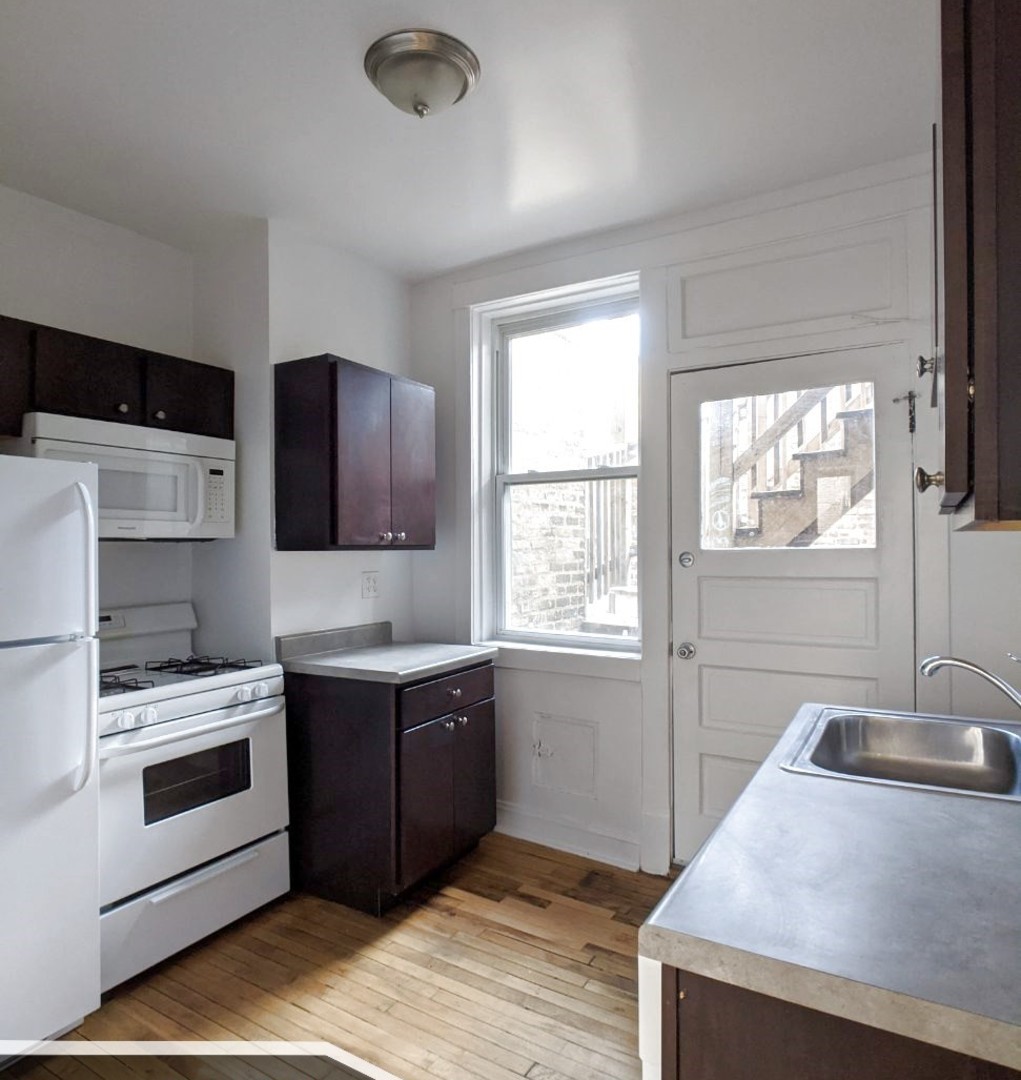 2919 West George Street, Unit 2 Chicago, IL 60618 - Photo 5 of 14 a kitchen with a stove a sink and a microwave