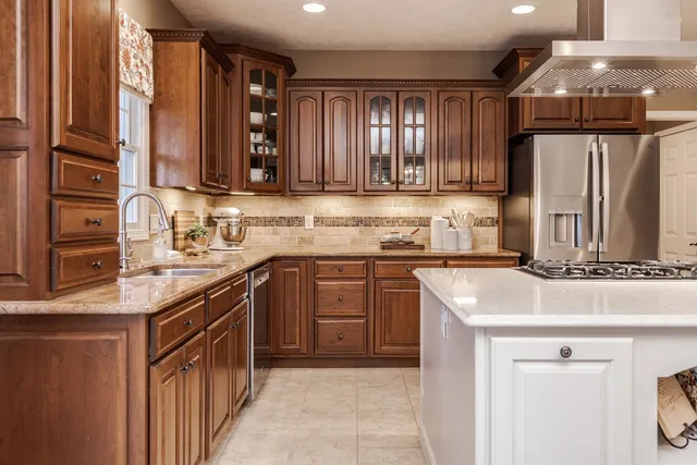 a kitchen with stainless steel appliances granite countertop a sink stove and refrigerator