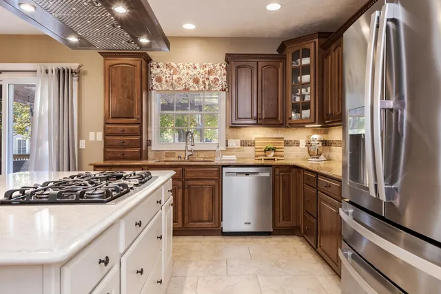 a kitchen with stainless steel appliances granite countertop a sink stove and refrigerator