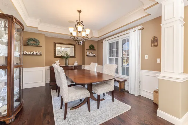 a view of a dining room with furniture a chandelier and wooden floor