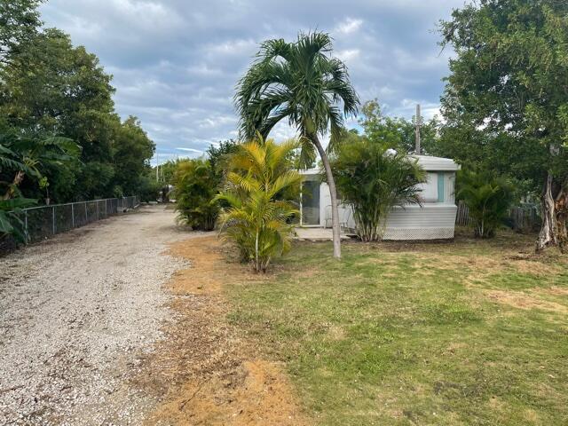 156 County Road Big Pine Key, FL 33043 - Photo 15 of 15 a backyard of a house with table and chairs plants and large trees