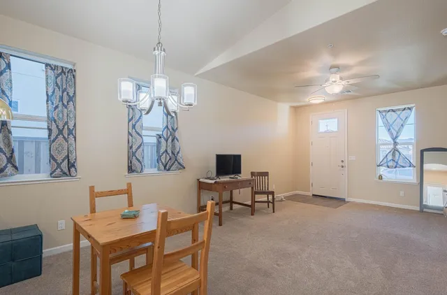 a kitchen with granite countertop a refrigerator a stove a sink dishwasher and wooden cabinets with wooden floor