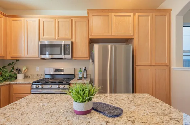 a kitchen with a granite countertop sink and cabinets