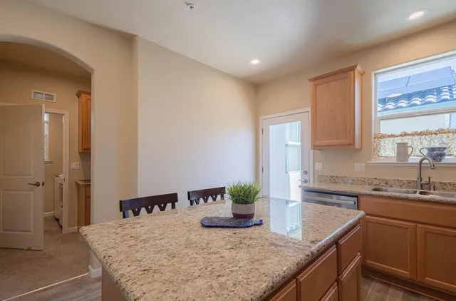 a kitchen with stainless steel appliances granite countertop a stove a sink and a microwave
