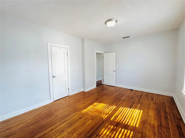 a view of a room with wooden floor and white walls