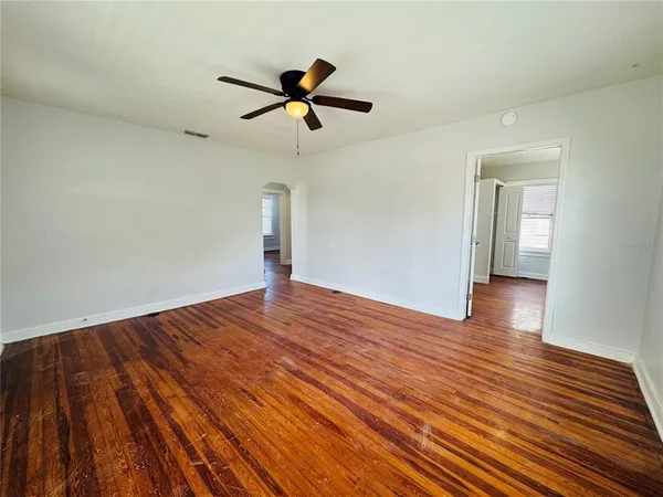 a view of empty room with wooden floor