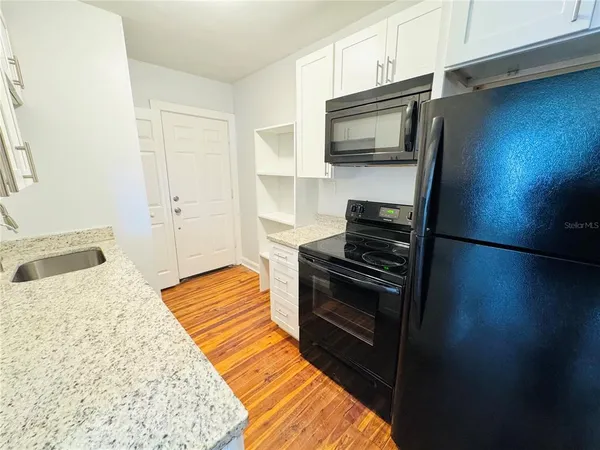 a kitchen with granite countertop stainless steel appliances and wooden cabinets