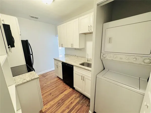 a view of a kitchen with fridge and wooden floor