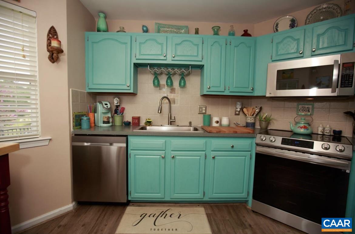 166 Oak View Road Barboursville, VA 22923 - Photo 18 of 46 a kitchen with green cabinets and a stove top oven
