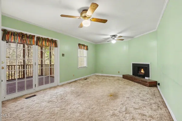 a view of an empty room with a fireplace and a window