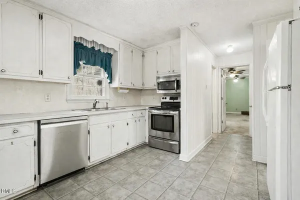 a kitchen with white cabinets and white appliances