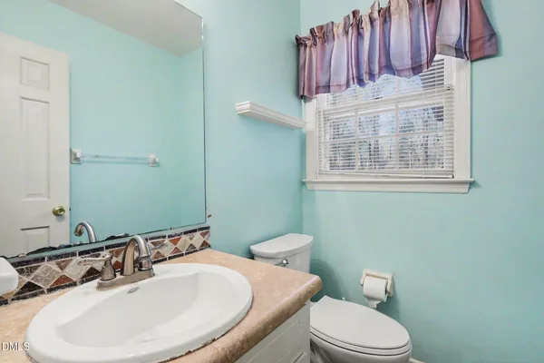 a bathroom with a sink a toilet and mirror