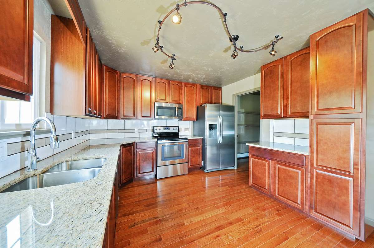 3453 1/2 G Road Clifton, CO 81520 - Photo 5 of 21 a kitchen with stainless steel appliances granite countertop a refrigerator a sink dishwasher a stove and white countertops with wooden floor