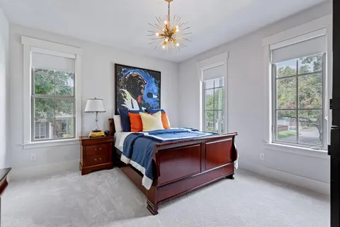 a bed sitting in a bedroom next to a window