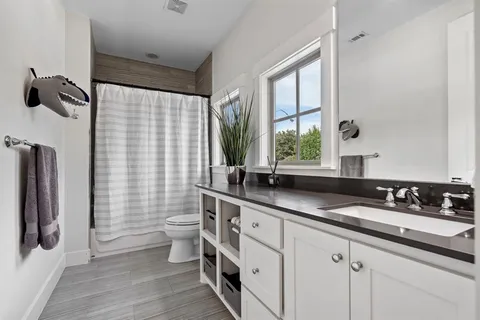 a bathroom with a double vanity sink toilet and shower