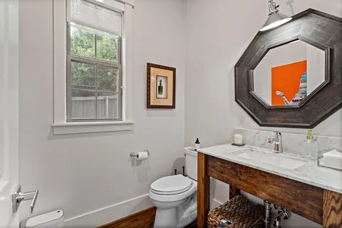 a bathroom with a toilet a sink and mirror