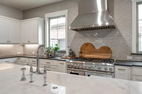 a kitchen with stainless steel appliances granite countertop a stove a sink and a microwave