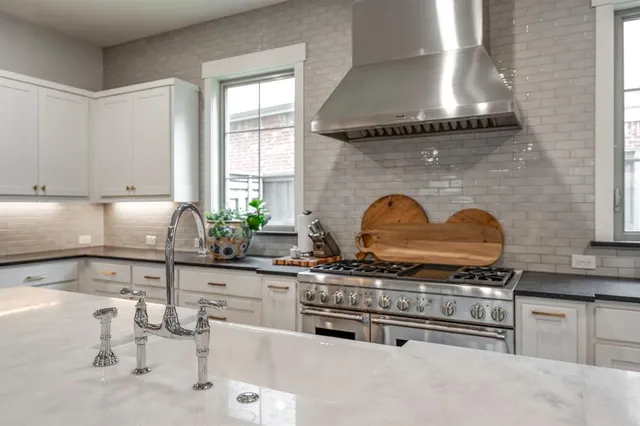 a kitchen with stainless steel appliances granite countertop a stove a sink and a microwave