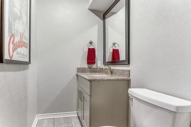 a bathroom with a granite countertop sink a toilet and a mirror