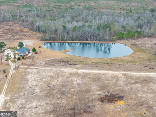 a view of a water pond with green field