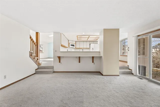 a view of an empty room with a kitchen