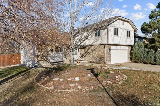 a view of a white house with a large tree